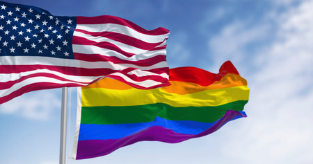 The American and LGBTQ+ Pride flags wave together against a clear sky. A powerful symbol of the fight for equality, diversity, and civil rights in the United States. 3D illustration.の写真素材