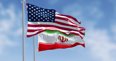 Iran and USA flags. Concept of conflict, diplomacy, sanctions, and international relations. Background for geopolitics and the nuclear deal, with copy space. Realistic 3D illustration.の写真素材