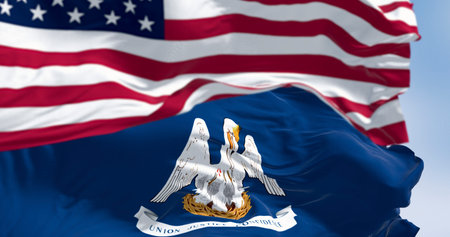 The Louisiana state flag waving in front of the US flag. Concept of state pride, American patriotism, and the relationship between state and federal government. Realistic 3D illustration.の写真素材