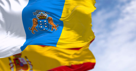Canary Islands and Spanish flag waving in the wind on a clear day. Spanish autonomous community. 3d illustration render. Selective focus. Close-up. Rippled fabricの写真素材