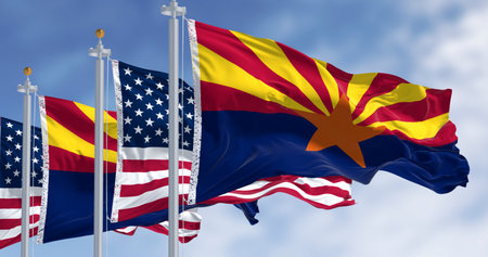 Flags of Arizona and United States waving in the wind on a clear day. Arizona is a state in the...