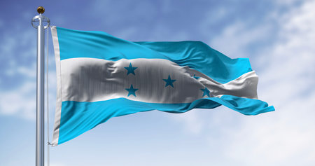 Honduran national flag waving in the wind on a clear day. Symbol of national pride, identity, and...