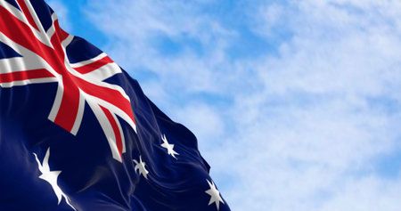 Australia national flag waving in the wind. Blue flag with Union Jack, white 5-pointed star...