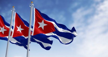 Three Cuban flags with iconic blue, white, and red stripes, and a white star on a red triangle, wave against a vibrant blue sky. Representing national identity. 3D render illustration.の写真素材