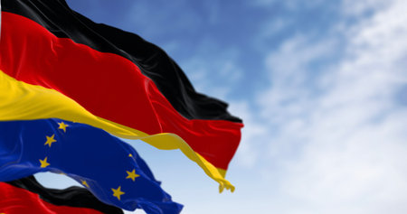 Flags of Germany and the European Union waving in the wind on a clear day. Germany became a member of the EU in January 1958. 3d illustration render. Fluttering fabric. Selective focus. Close-upの写真素材