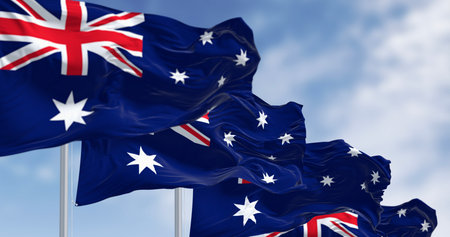 Australia national flags waving in the wind on a clear day. Blue flag with Union Jack, white 5-pointed star symbolizing Southern Cross. 3D illustration render. Selective focusの写真素材