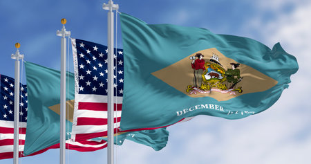 Delaware state flag waving with the national american flag. Yellowish-beige rhombus shape with the state coat of arms on a pale blue background. 3d illustration render. Selective focusの写真素材