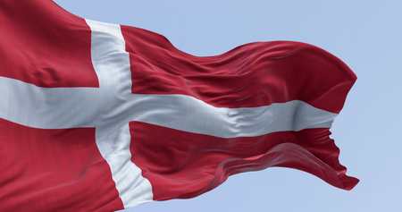 Close-up of Denmark national flag waving on a clear day. Red flag with a white Scandinavian cross extending to the edge of the flag. 3d illustration render. Fluttering fabric. Selective focusの写真素材