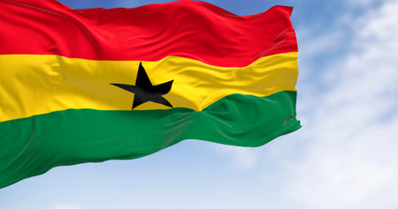 National flag of Ghana waving on a clear day. Three equal horizontal stripes, red, yellow with black...