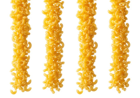 Dry elbow macaroni pasta pieces arranged vertically in four distinct columns on a clean white background. Uncooked, food ingredient.の素材