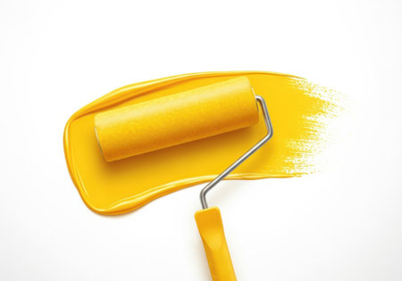 A close-up shot of a yellow paint roller spreading a vibrant yellow paint stroke across a clean white background.の素材