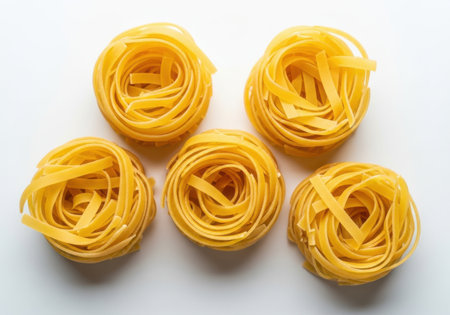 Italian pasta fettuccine nest on a white acrylic background.の素材