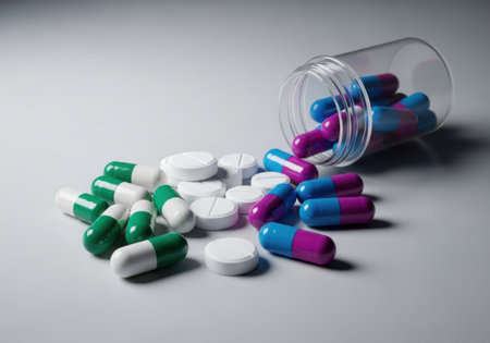 Pills spilling out of pill bottle on white background. Focus on foreground, soft bokeh.の素材