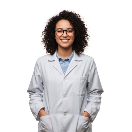 A young woman with curly hair and glasses wears a white lab coat and smiles confidently. She stands against a white background.の素材