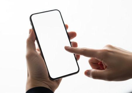 A close-up shot of a person's hands holding and interacting with a smartphone that has a blank white screen.の素材