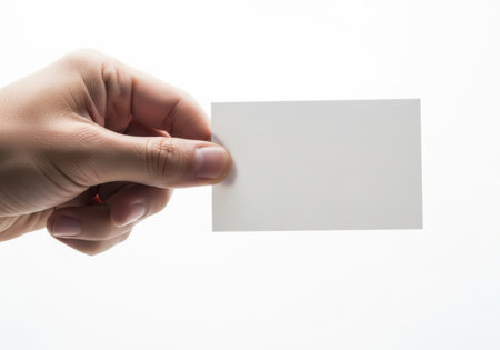 A person's hand holds a blank white card, ready for information. The background is stark white.の素材