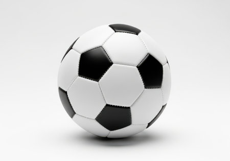 A traditional black and white soccer ball is presented in a studio setting on a plain white surface.の素材