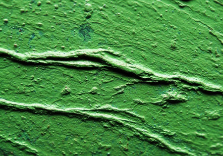 A close-up view of a textured green surface with prominent raised lines and small imperfections, suggesting a painted or stuccoed wall.の素材