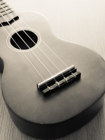 Bridge of Ukulele on wooden background, Shallow in DOF