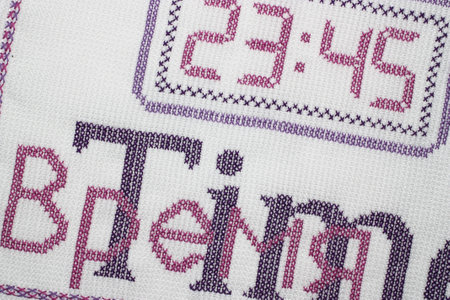 Embroidery depicting clock in purple