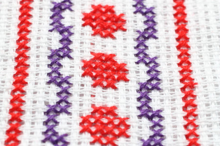 Embroidery with a geometric pattern of red and purple colors