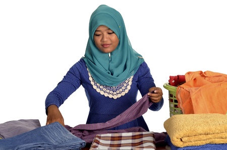 Young Muslim Asian lady folding clothesの写真素材