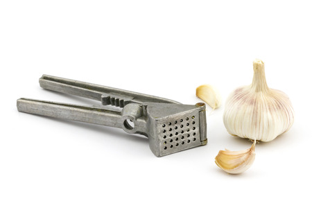 Closeup view of garlic crusher with garlic isolated on white backgroundの写真素材