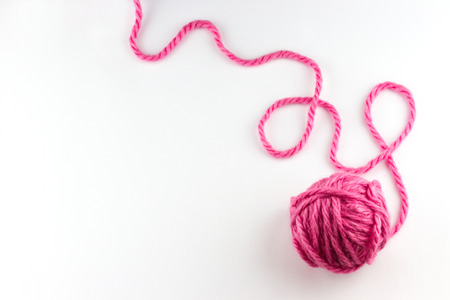 Top view of pink yarn ball with woolen thread on white backgroundの写真素材