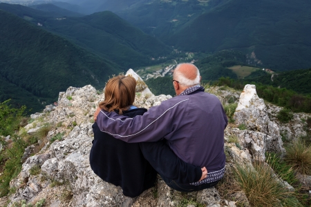 Senior couple enjoying the view from the top of the mountainの写真素材
