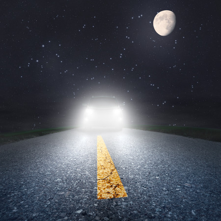 Driving on an asphalt road towards the headlightsの写真素材