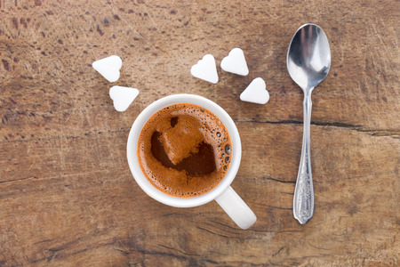 Cup of coffee with sugar cubes in shape of heart from aboveの写真素材