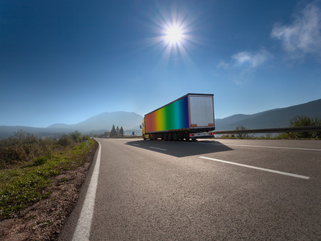 Truck in rainbow color on the highway at sunny dayの写真素材