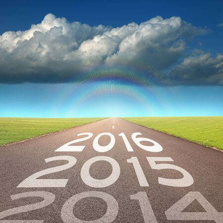 Driving on an empty road towards the big cloud and rainbow to upcoming 2016 and leaving behind old...