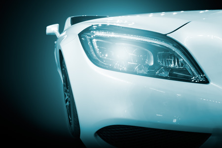 White modern car closeup of headlight. Exterior detail, shallow depth of field.の写真素材