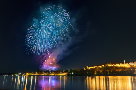 Cityscape and fireworks at the foot of the famous tourist landmark Kalemegdan fortress at night, with reflection on river Sava. Belgrade - Serbia.のeditorial素材