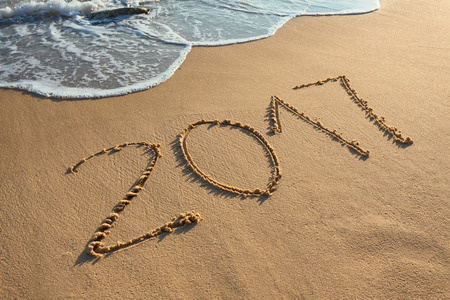 Number 2017 handwritten on seashore sand. Concept of upcoming new year and passing of time.