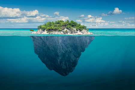 Beautiful underwater view of lone small island above and below the water surface in turquoise waters...