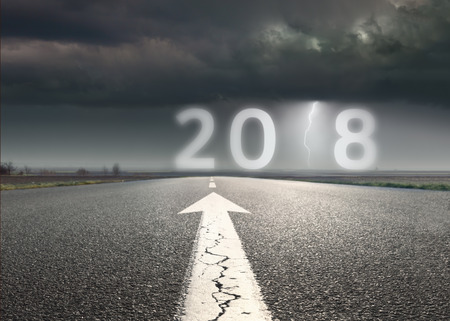 Driving on an empty road towards troublesome and uncertain new year 2018. Future and prediction concept.の写真素材