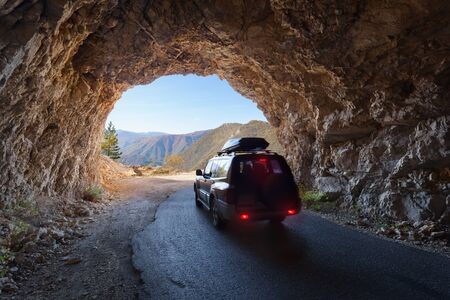Off road vehicle driving through old tunnel in beautiful Piva river canyon, Montenegro. Adventure...