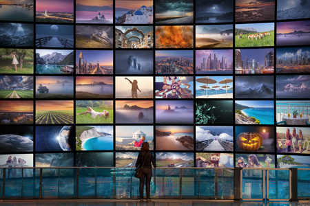Big video wall in television production room as technology concept with colorful screens and human sihouette in front of it.の写真素材
