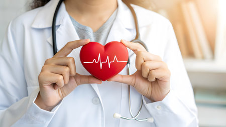 Close up of female doctor holding red heart with cardiogram symbolの素材
