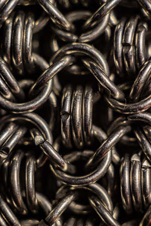 texture of chain mail close-up. macro photo of metal rings United in a chain in rows, forming the...