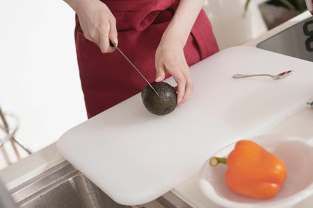 Young Woman Cutting Avocadoの写真素材