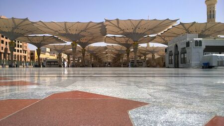 An external image of the Prophet's Mosque in Medina in Saudi Arabia, Show It shows umbrellas which protects from the sun and the minarets of the mosque.のeditorial素材