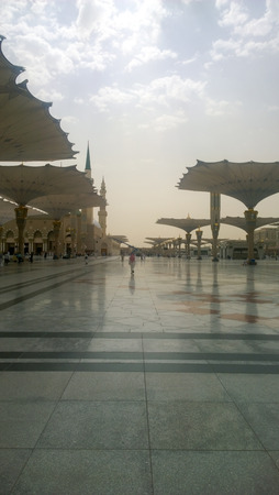 An external image of the Prophet's Mosque in Medina in Saudi Arabia, Show It shows umbrellas which protects from the sun and the minarets of the mosque.のeditorial素材