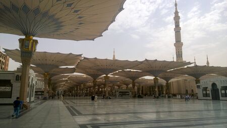 An external image of the Prophet's Mosque in Medina in Saudi Arabia, Show It shows umbrellas which protects from the sun and the minarets of the mosque.のeditorial素材