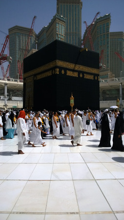 Picture of the Kaaba and a group of pilgrims they walk around to perform Hajj or Umrah, and all Muslims follow its, Located in Mecca in Saudi Arabia.のeditorial素材