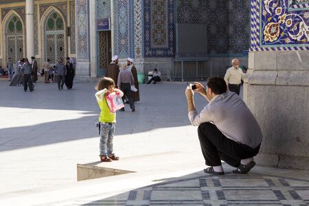 Picture of a man portrayed his daughter souvenir photo inside the shrine of Fatima in the Iranian city of Qom.のeditorial素材