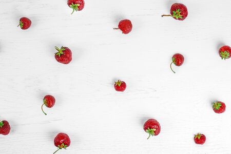 Colorful pattern of strawberries on white wood background. Top viewの写真素材