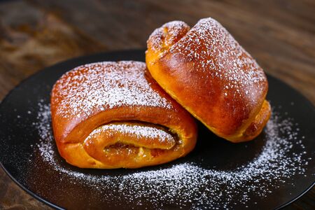 Baking on a black plate. Sweet Buns With Icing Sugarの写真素材
